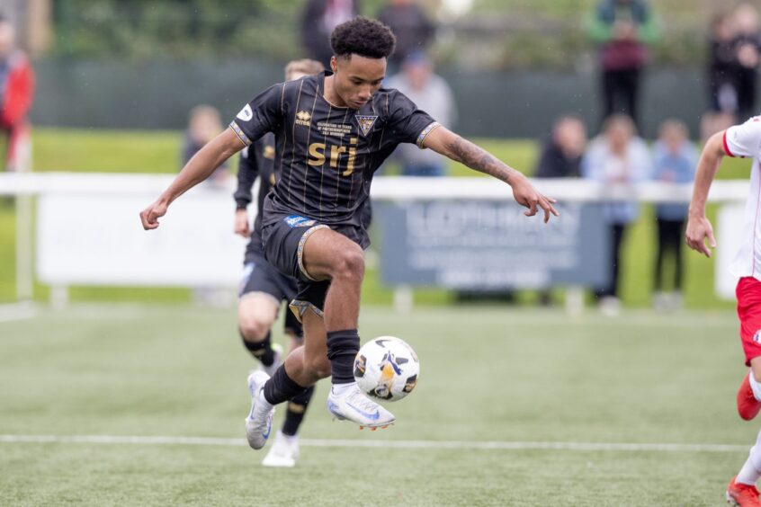 Kane Ritchie-Hosler concentrates as he controls the ball with his right foot.