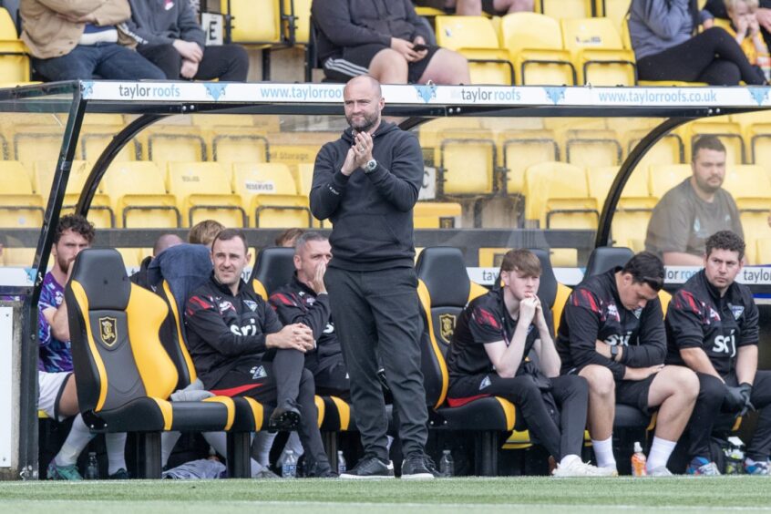 Pars manager James McPake stands in front of the Dunfermline dugout.