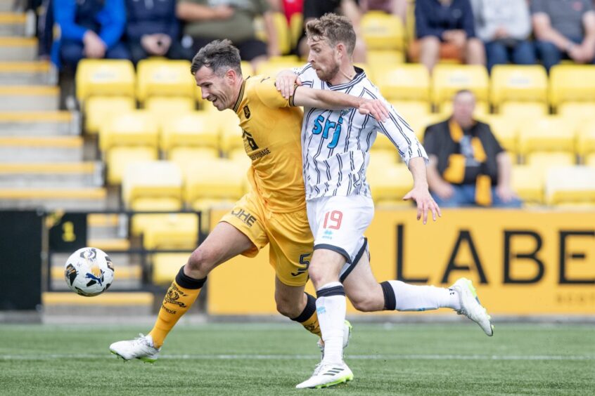 Dunfermline Athletic FC midfielder David Wotherspoon is held off by Livingston defender Ryan McGowan.