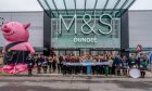 Staff celebrating the opening day of Dundee M&S with a pipe band and giant Percy Pig.