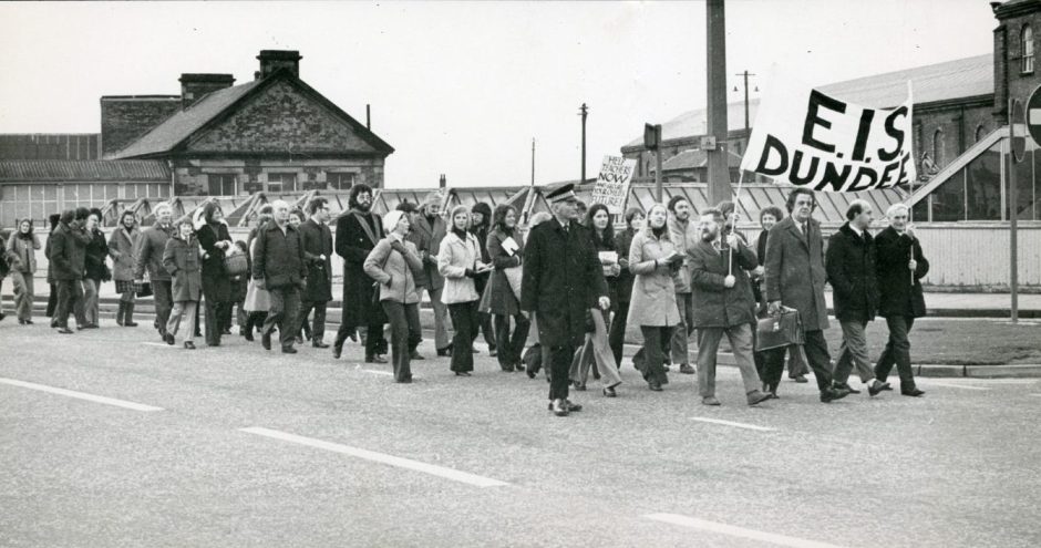 Teachers marching on a road with an EIS Dundee banner.