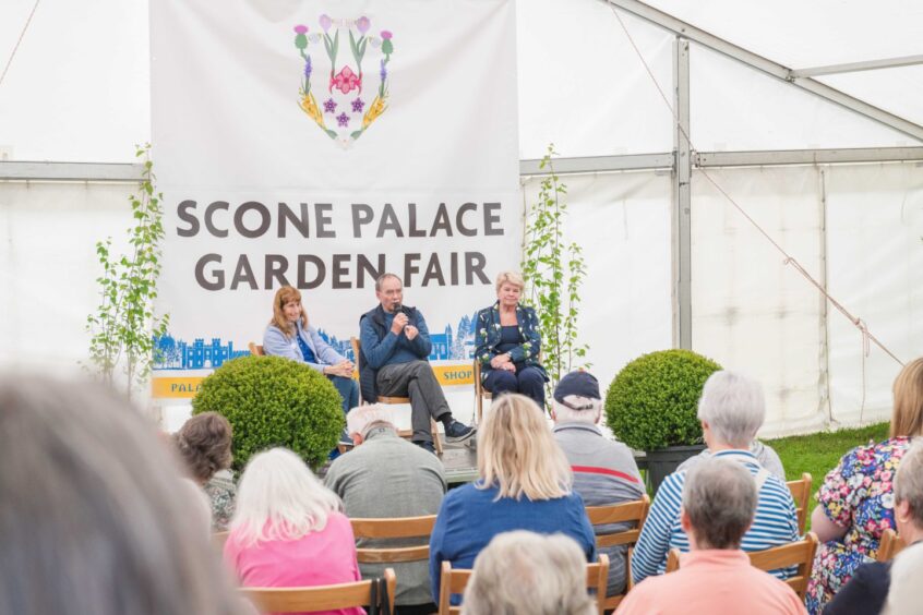 People on panel in ten in front of scone palace garden fair banner