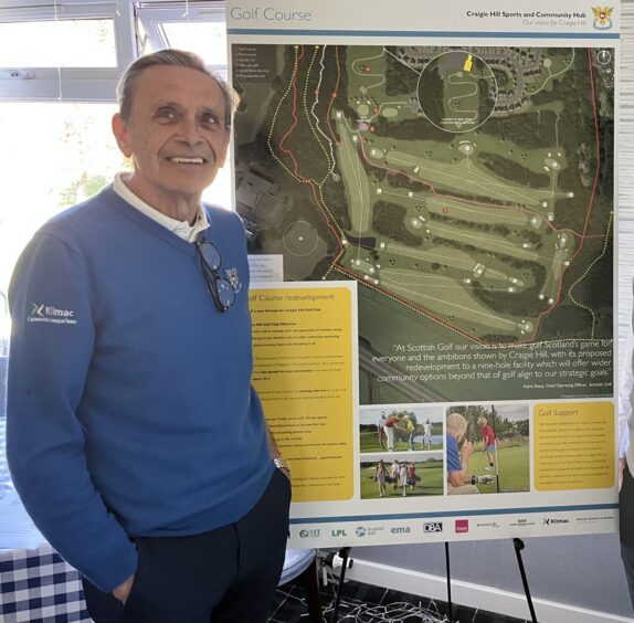 Dave Mitchell next to board with plans for golf course on it