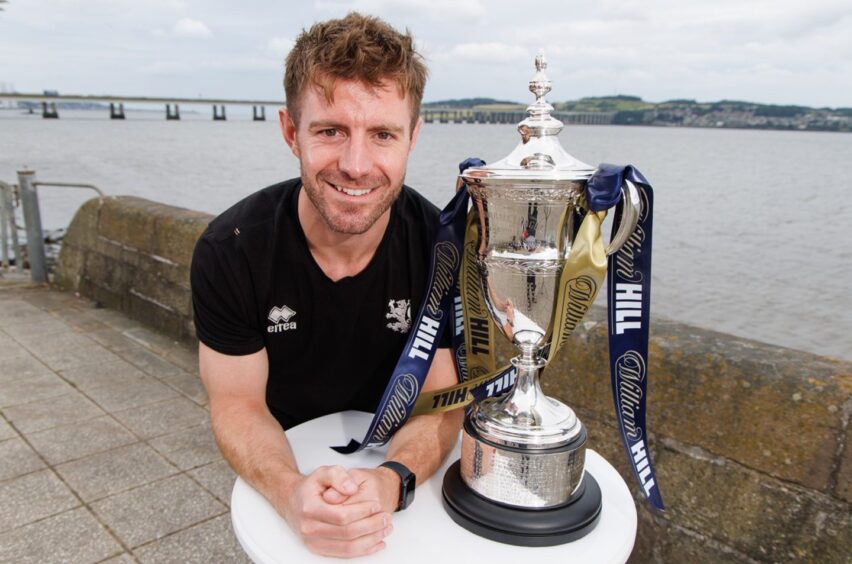 Ross Docherty with the Championship trophy he held aloft last term