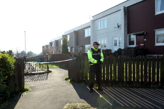 A police officer standing guard in Whitfield Avenue, Dundee, in March 2022.