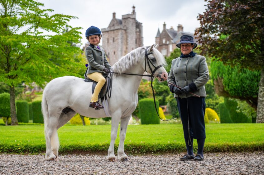 Woman with small child on pony