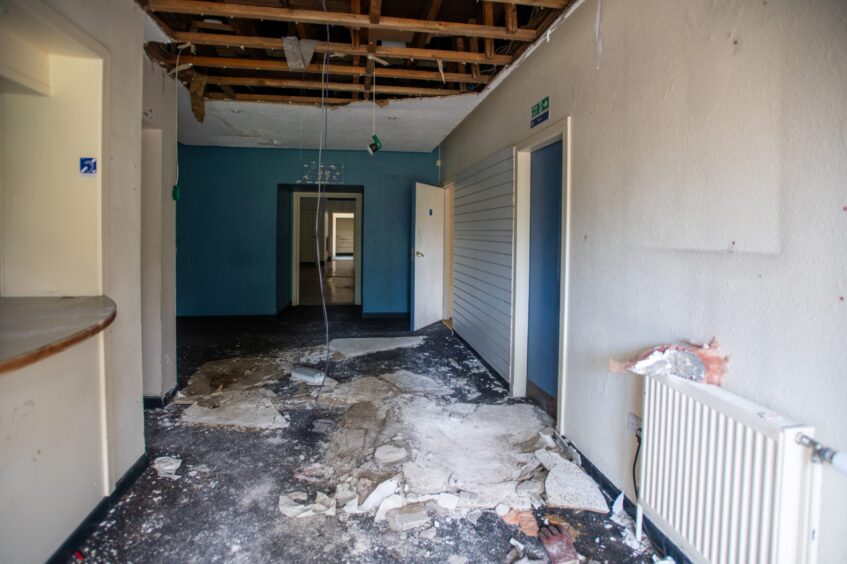 Entrance to Rodney pavilion with collapsed ceiling and debris all over carpet