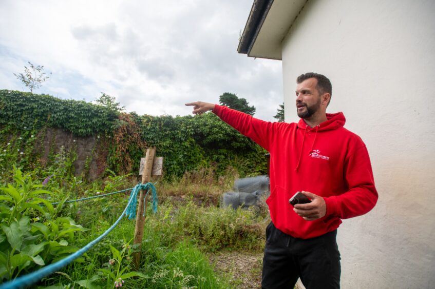 Kevin Cutbert next to overgrown area outside Rodney Pavilion