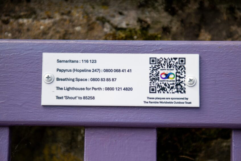 Plaque on bench with phone numbers for the Samaritans and other mental health support organisations