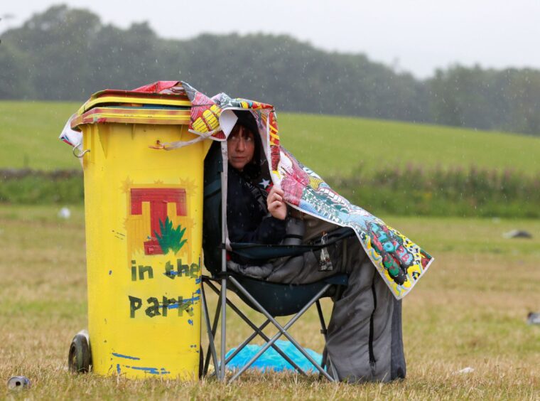 Lyndsay Mackie, from Fife, shelters from the rain in the festival campsite.