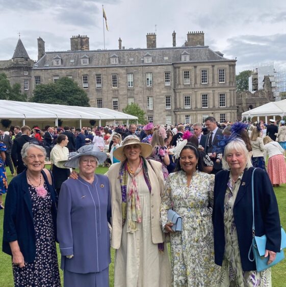 Margaret Smith, Vivian Mann, Gina Purrmann, Gameeda Barnard and Anne Gray smartly dressed in front of palace of Holyroodhouse and other garden party guests