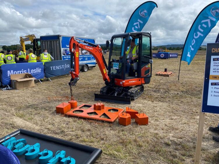 Man in digger moving pieces of metal in competition