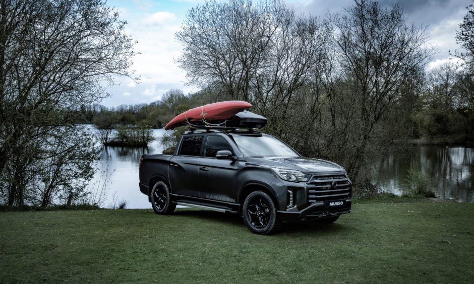 the car parked beside a pond with a kayak on its roof