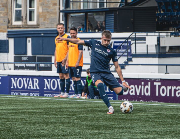 Raith Rovers winger Lewis Gibson sends in a cross with his left foot.