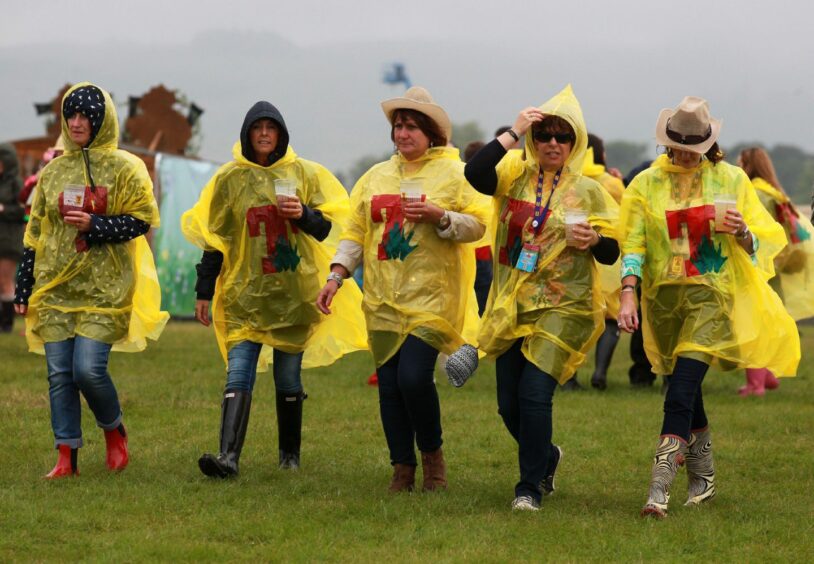 Tin the Park festival-goers use ponchos to shelter from the rain on Saturday. 