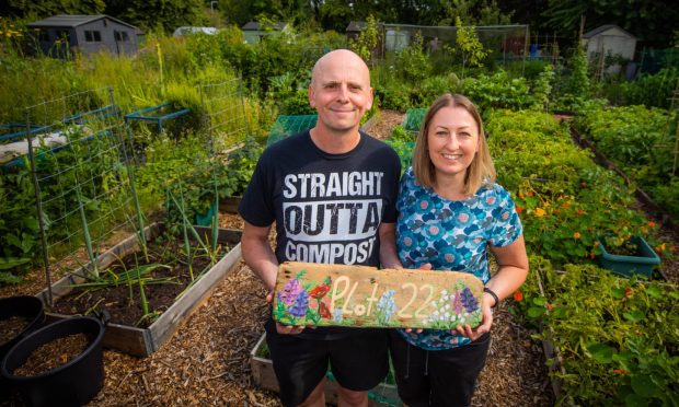 Calum Harvie and wife Louise Harvie with a 'plot 22' sign made by one of Louise's Bell Baxter High School pupils for their allotment at Elmwood College Allotments in Cupar.