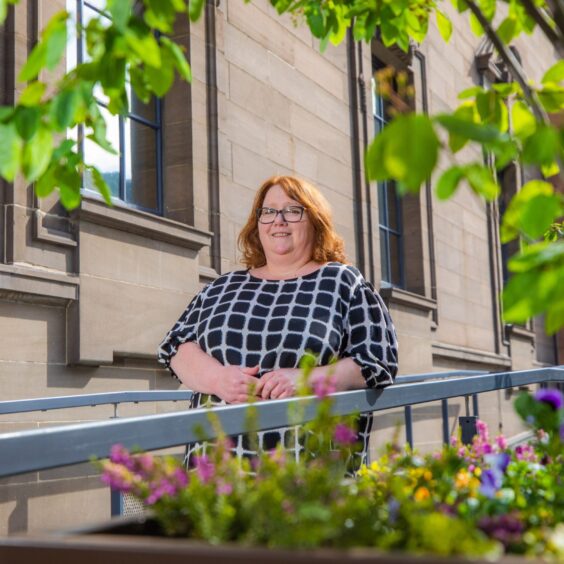 Helen Smout leaning on railing outside Perth Museum