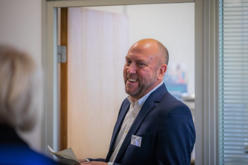 David Littlejohn smiling in suit and open-necked shirt