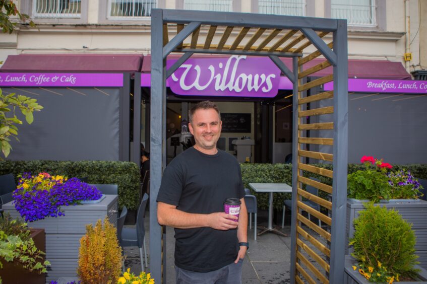 Michael White holding cup of coffee outside Willows coffee shop in Perth