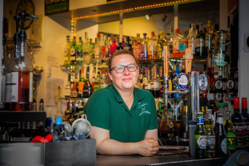 Roxy Stefan smiling arms folded at bar in Crido's restaurant, Perth