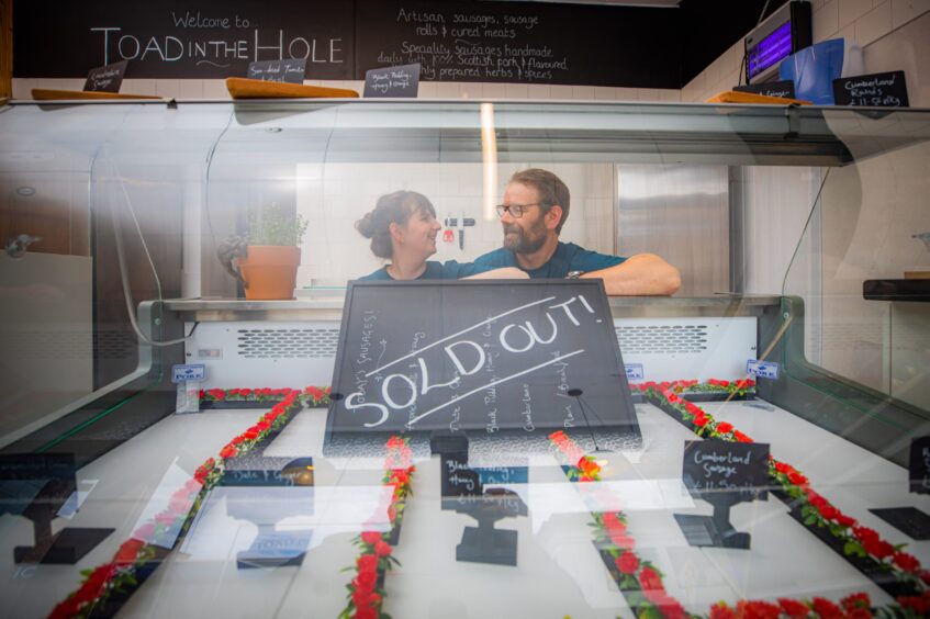 Aaron and Olivia Young behind 'sold out' sign on empty sausage shop counter