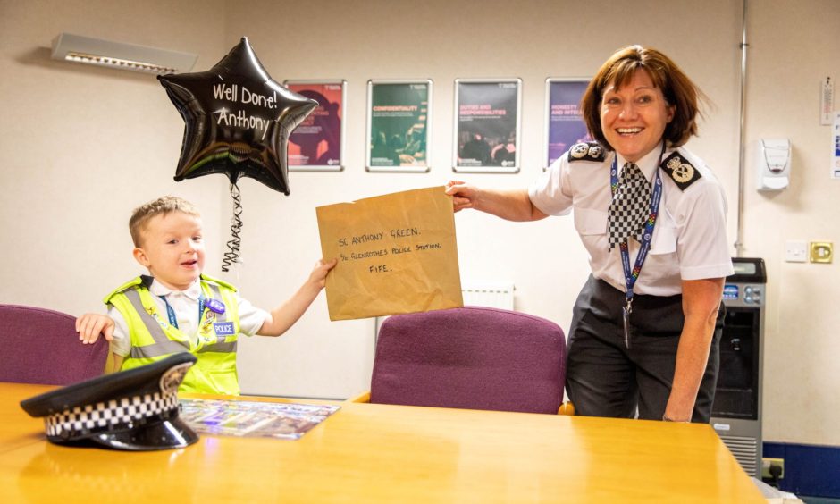 Anthony Green gets a certificate from the chief constable for his efforts at Glenrothes police station