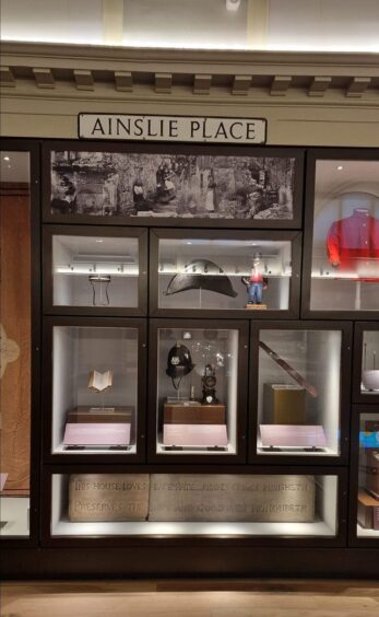 Ainslie Place street sign on wall above display case in Perth Museum