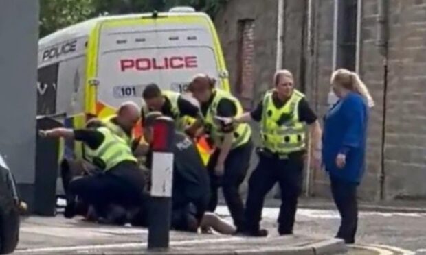 Police arresting the man on Strathmartine Road. Image: Supplied