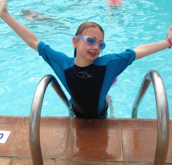 Taylor, pictured age 7, has loved swimming from a young age.