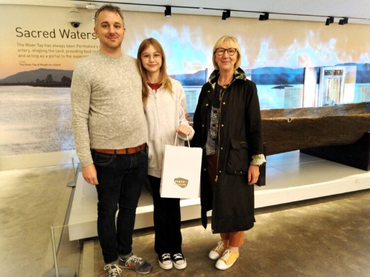 The McEwan Family standing in front of Carpow logboat at perth Museum
