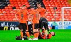 Dundee United players surround the stricken Ryan Strain