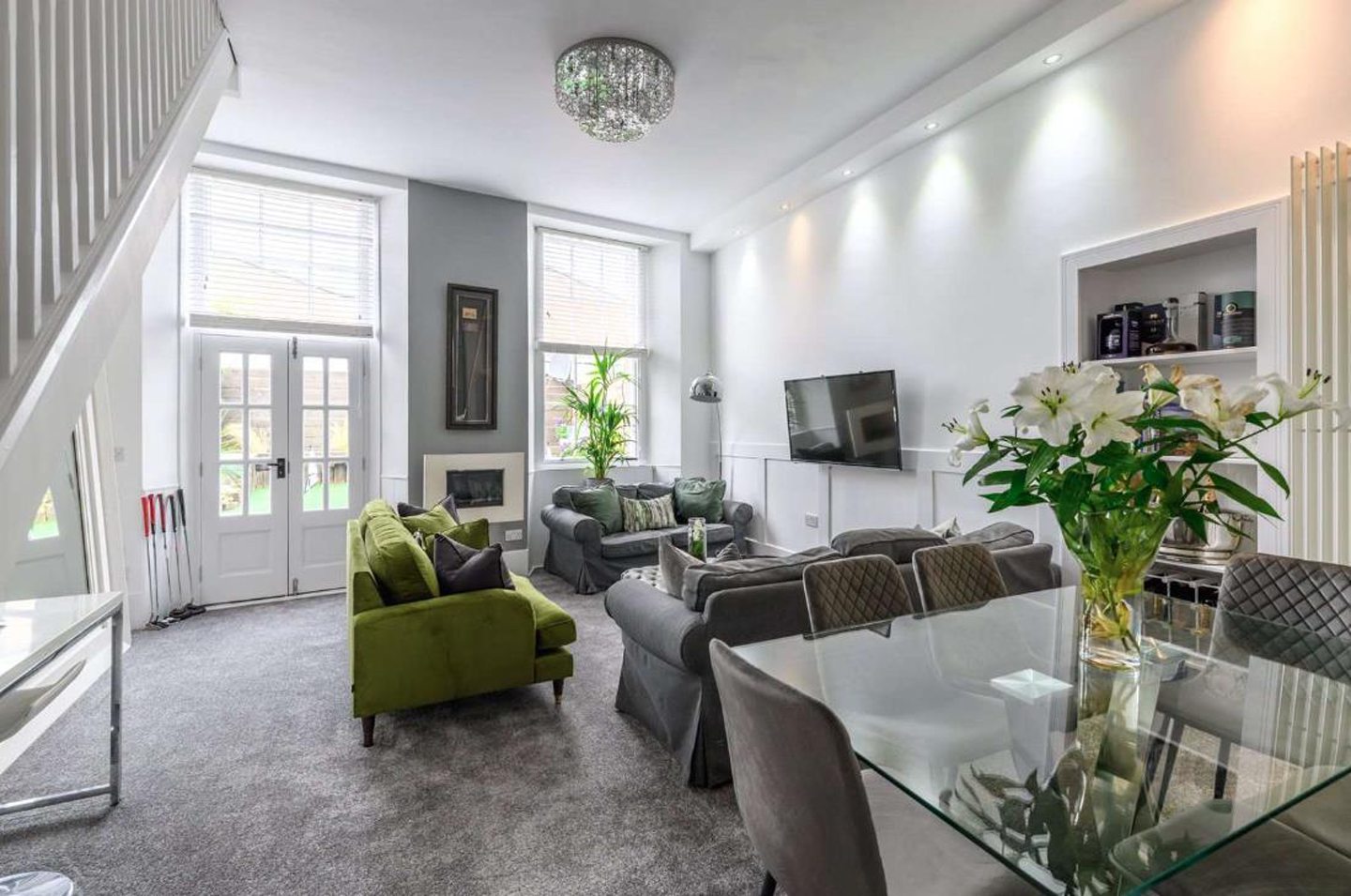 The living room with a raised fire place and wall-mounted television.