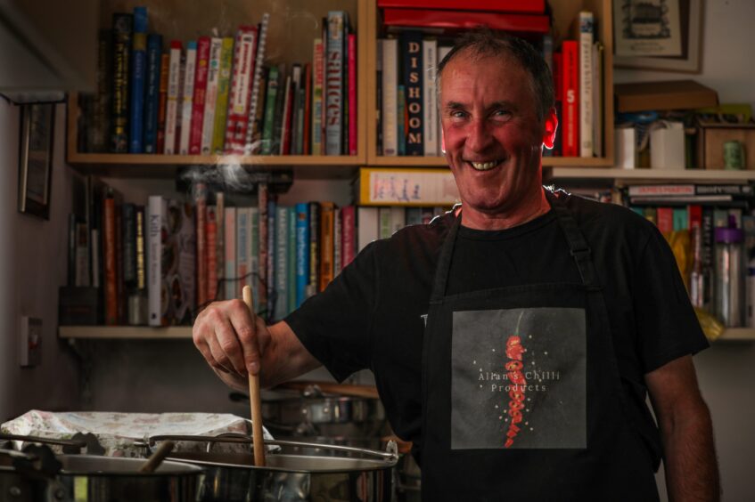 Allan Ferguson stirs the pot of chilli sauce.