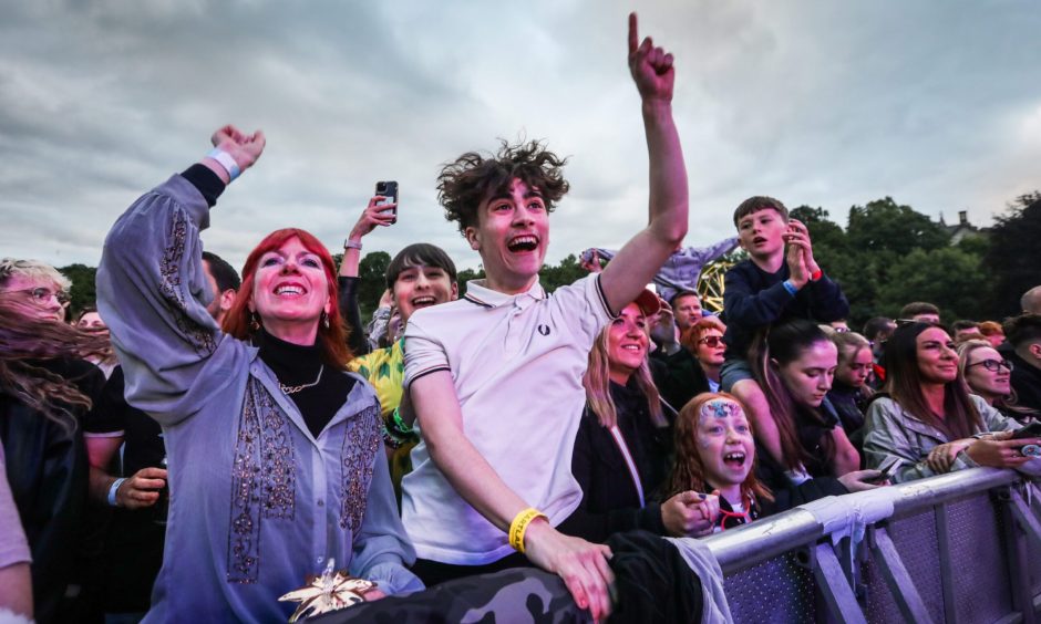 Crows raising hands in air at front of stage at Heartland Festival