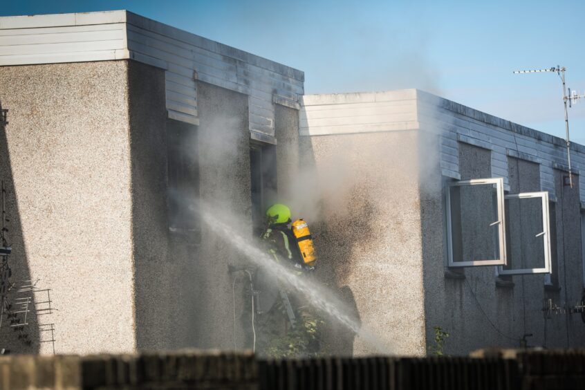 A firefighter wearing breathing apparatus tackles the blaze.