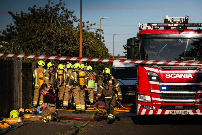 Fire crews use breathing apparatus whilst trying to extinguish the fire on Linfield Street.