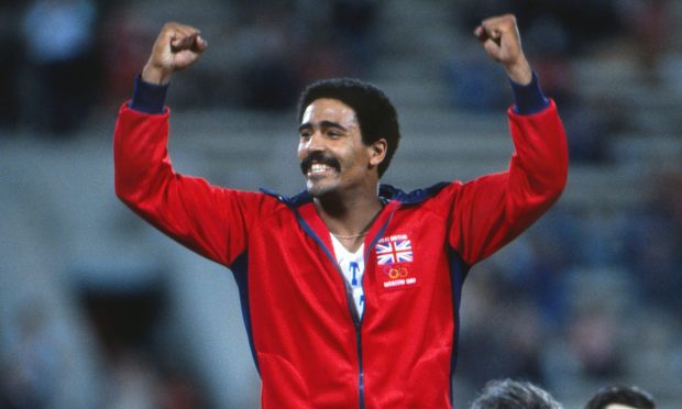 Daley Thompson holds two hands in air at 1980 Olympics.