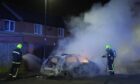 Firefighters tending to a burning police car on the streets of Hartlepool on July 31, following violent disorder in the city. Image: Owen Humphreys/PA