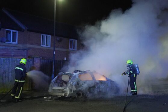 Firefighters tending to a burning police car on the streets of Hartlepool on July 31, following violent disorder in the city. Image: Owen Humphreys/PA