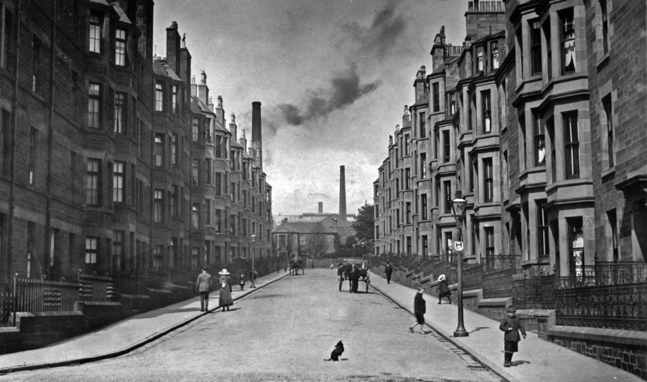 People walking up and down Bellefield Avenue, as smoke billows from a chimney in the distance. 