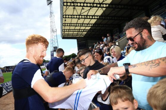 Simon Murray signs autographs for Dundee fans at Dens Park. Image: David Young