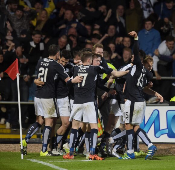 Craig Wighton is mobbed by his Dundee team-mates after scoring his derby winner against Dundee United in 2016.