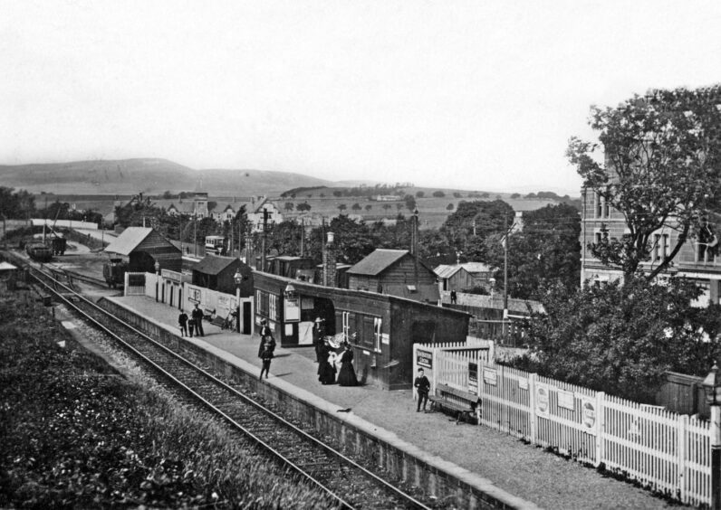 People on the platform in an aerial shot of Baldovan Station in the golden age of steam. 