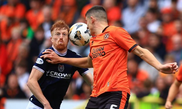 Simon Murray of Dundee challenges for the ball with Ross Graham of Dundee United at Sunday's derby. Image: David Young/Action Plus/Shutterstock