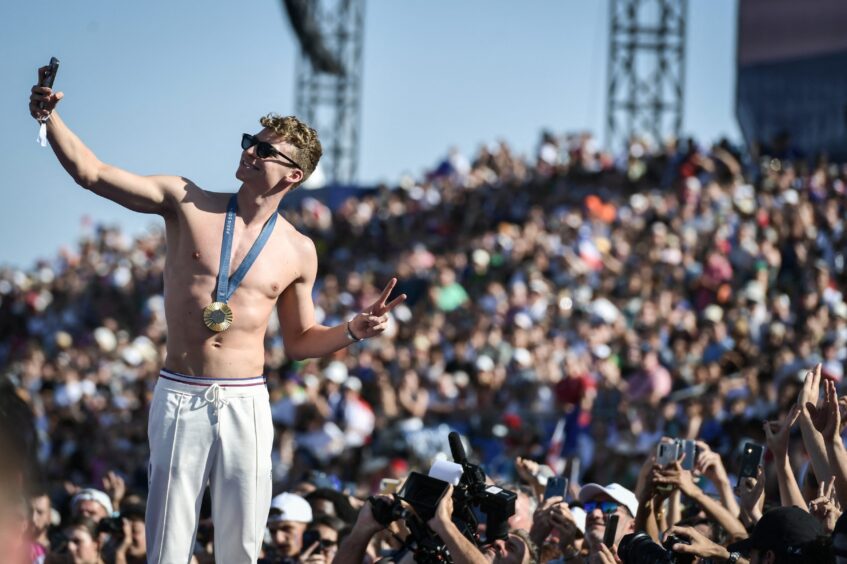 France's star swimmer Leon Marchand arrives as fans welcome champions at the Parc des Champions at Trocadero.