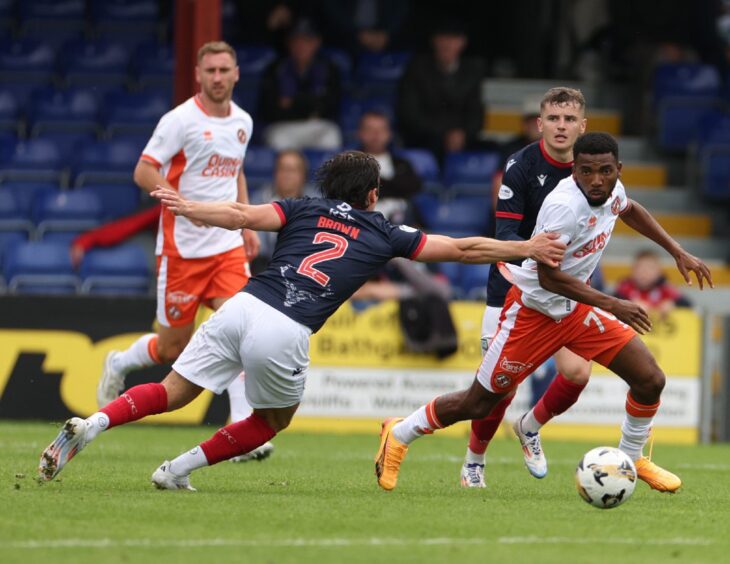 Dundee United's Meshack Ubochioma skips past James Brown on his debut.