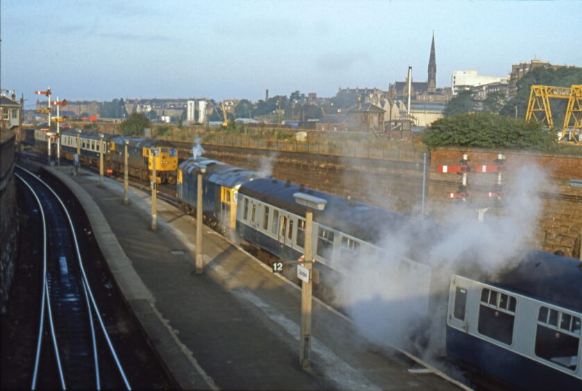 Diesel fumes fill the station in the 1980s, with the cityscape visible in the background