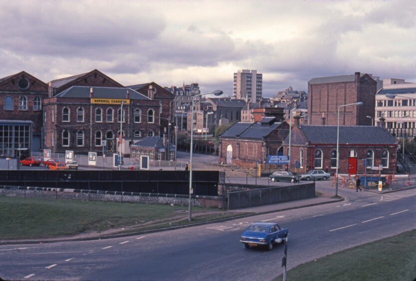 A car drives by Dundee West Goods Yard in 1984.