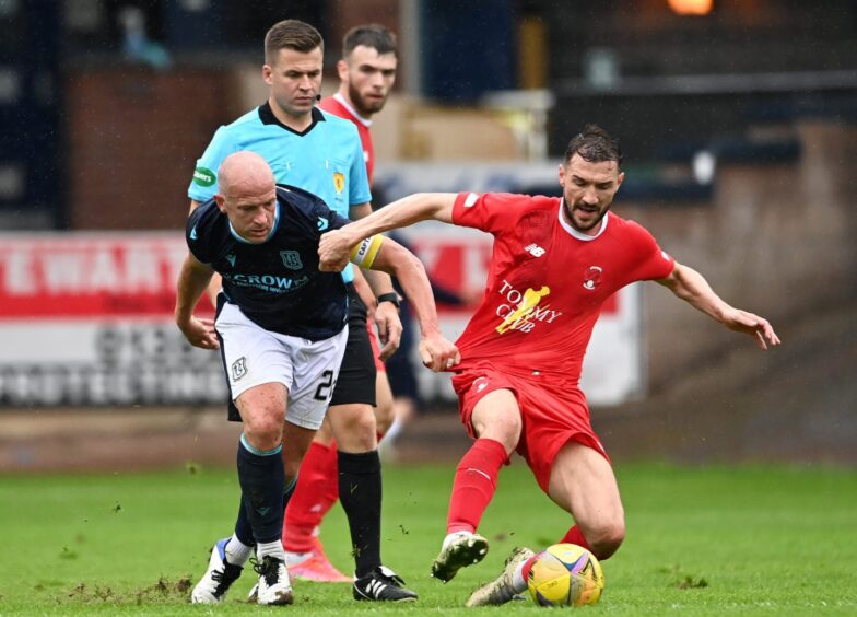 Craig Clay challenges Dundee's Charlie Adam during Leyton Orient's pre-season friendly at Dens Park in 2021. 