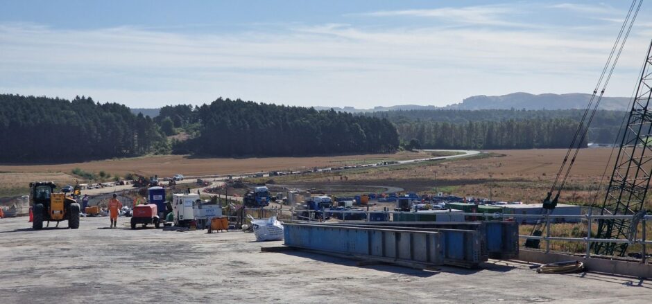 Constriction materials and workers on Destiny Bridge looking east as the new road snakes through the countryside